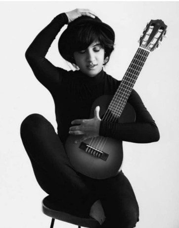Black and white studio portrait with guitar